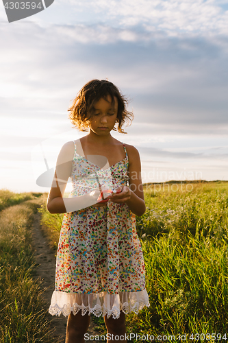 Image of Girl holding kite and running in field