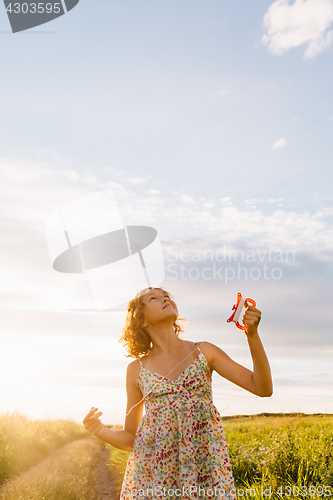 Image of Girl holding kite and running in field