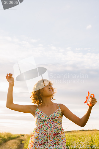 Image of Girl holding kite and running in field