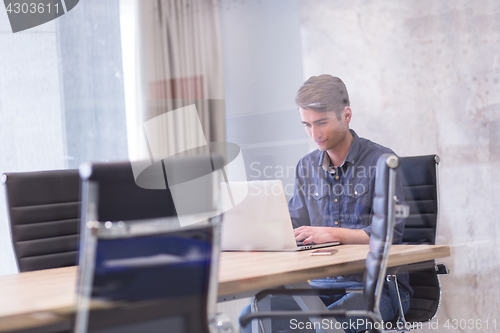 Image of businessman working using a laptop in startup office