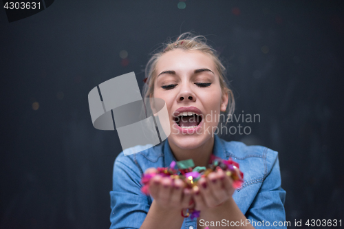 Image of woman blowing confetti in the air