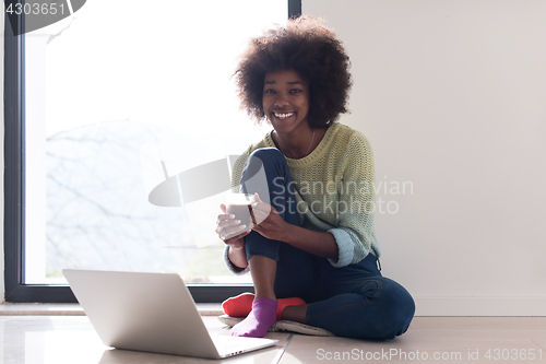 Image of black woman in the living room on the floor