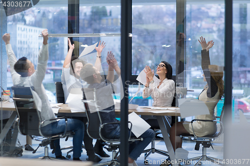 Image of startup Group of young business people throwing documents