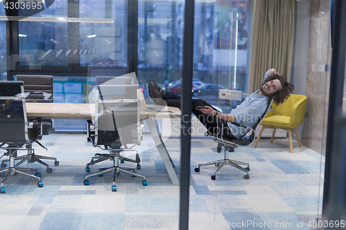 Image of young businessman relaxing at the desk