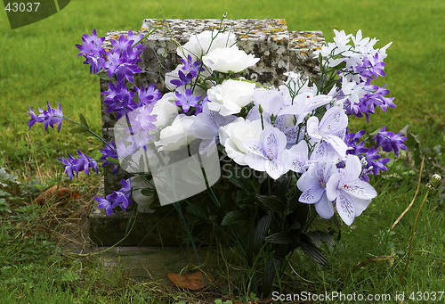 Image of Purple and white flowers on a grave