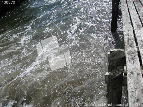 Image of Stirred up water against a old wooden dock