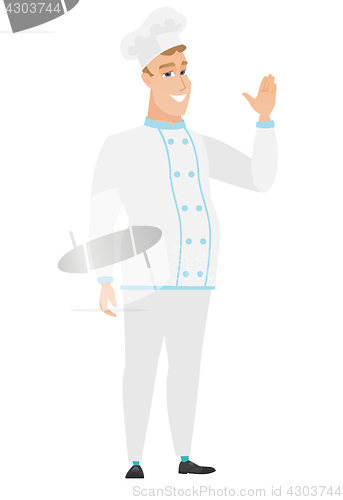 Image of Young caucasian chef cook waving his hand.