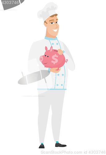 Image of Caucasian chef cook holding a piggy bank.