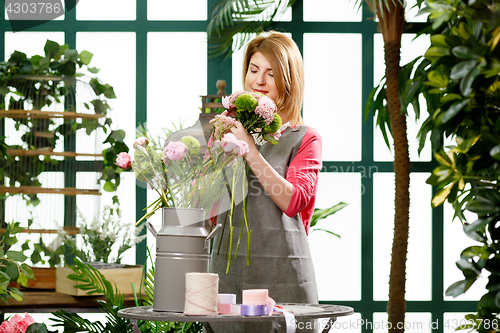 Image of Woman making composition of flowers