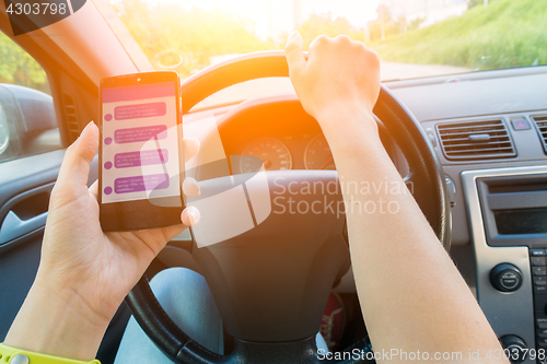 Image of Driver keeps smartphone with correspondence