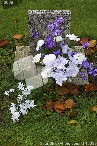 Image of Purple and white flowers on a grave