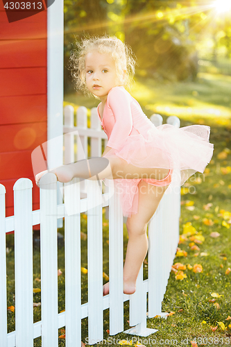 Image of The little girl at playground against park or green forest