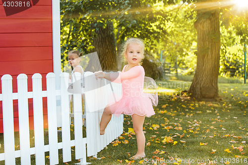 Image of The two little girls at playground against park or green forest