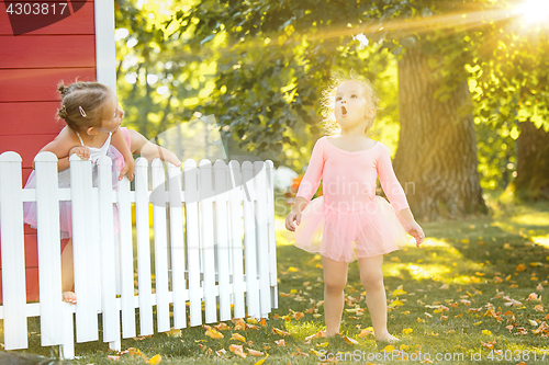 Image of The two little girls at playground against park or green forest