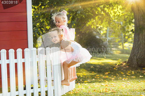 Image of The two little girls at playground against park or green forest