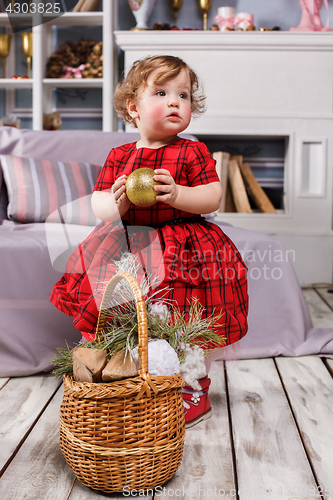 Image of Little girl standing at studio with christmas decorations
