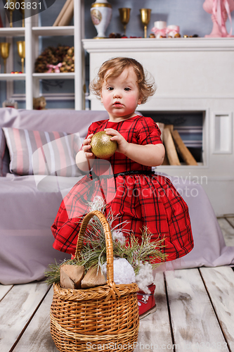 Image of Little girl standing at studio with christmas decorations