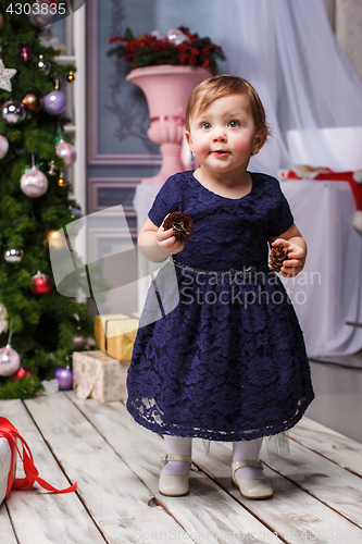 Image of Little girl standing at studio with christmas decorations