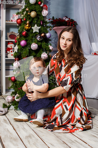 Image of Little girl With her happy mother at studio with christmas decorations