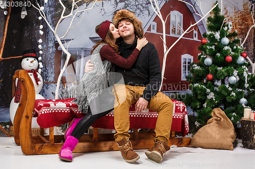 Image of Happy young couple with Christmasd ecorations tree at home