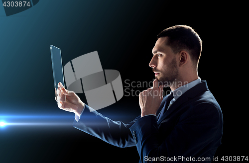 Image of businessman working with transparent tablet pc