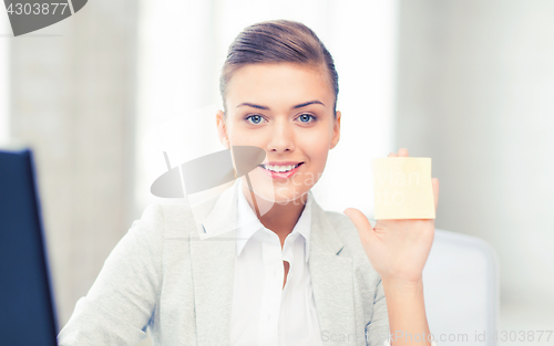 Image of smiling businesswoman showing sticky note