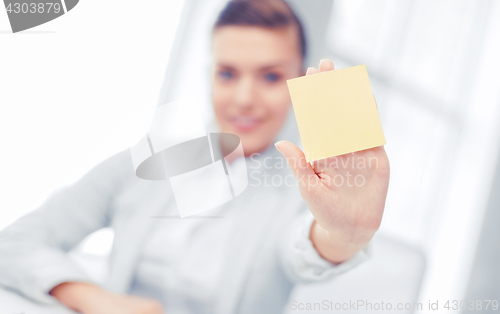 Image of smiling businesswoman showing sticky note