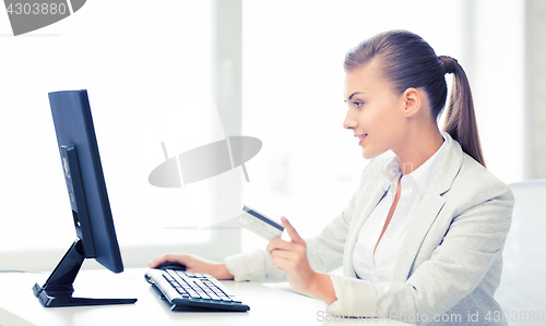 Image of businesswoman with computer using credit card