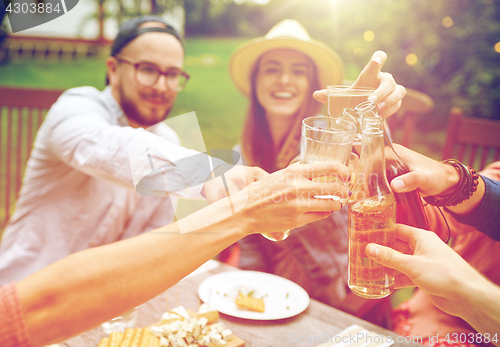 Image of happy friends with drinks at summer garden party