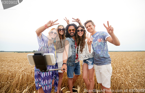 Image of hippie friends with smartphone on selfie stick