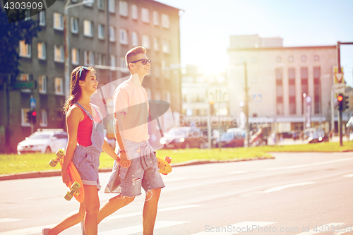 Image of teenage couple with skateboards on city street