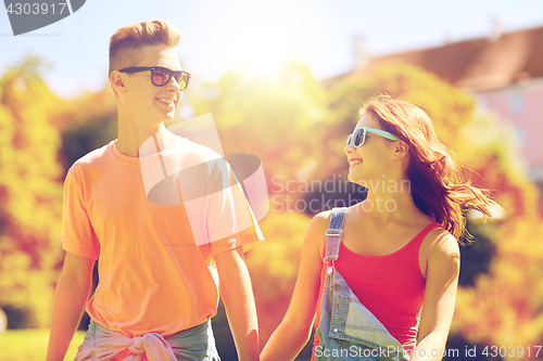 Image of happy teenage couple walking at summer park