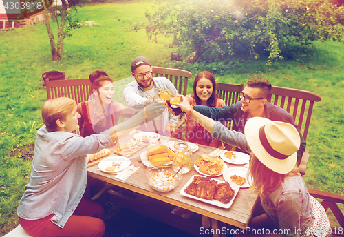 Image of happy friends having dinner at summer garden party