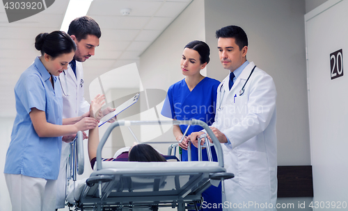 Image of medics with woman on hospital gurney at emergency