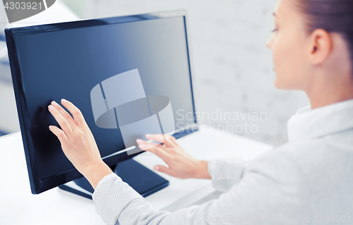 Image of smiling businesswoman with touchscreen in office