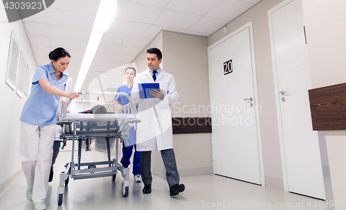 Image of medics with woman on hospital gurney at emergency