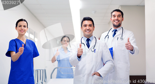 Image of happy doctors showing thumbs up at hospital