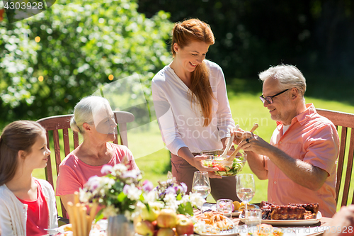 Image of happy family having dinner or summer garden party