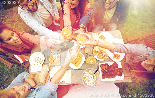 Image of happy friends with drinks at summer garden party