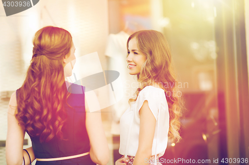 Image of two happy women talking at shop window