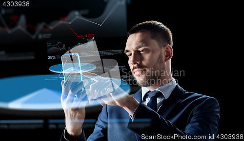 Image of businessman with smartphone and virtual charts