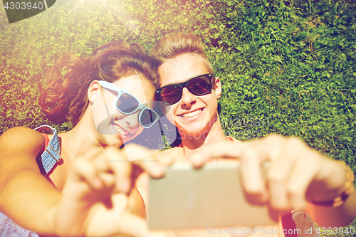 Image of happy couple taking selfie on smartphone at summer