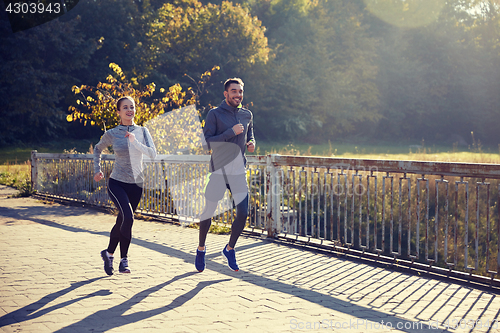 Image of happy couple running outdoors