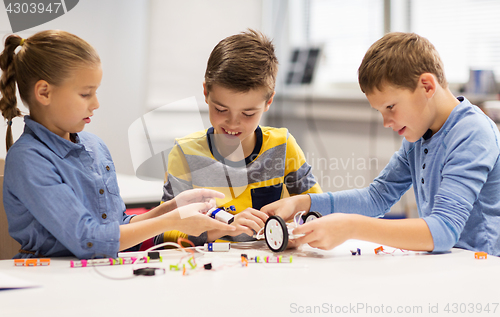 Image of happy children building robots at robotics school