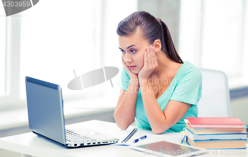 Image of stressed student with computer at home