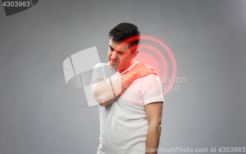 Image of unhappy man suffering from pain in shoulder