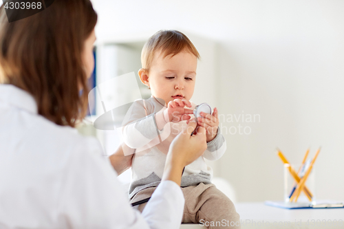 Image of doctor with stethoscope and happy baby at clinic