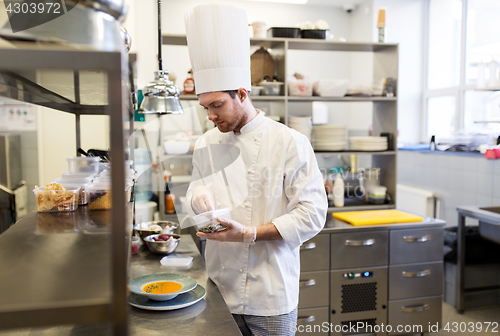 Image of happy male chef cooking food at restaurant kitchen