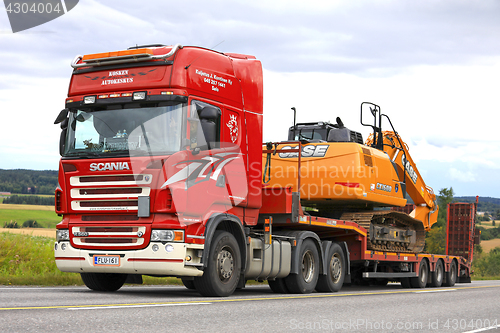 Image of Red Scania Semi Trailer Hauls New Case Excavator