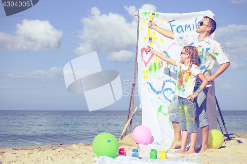 Image of Father and daughter playing on the beach at the day time.